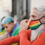 Diverse gay people at pride parade - Focus on hipster senior man wearing safety face mask